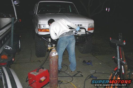 1995 Ford Bronco front end with custom bumper, person welding