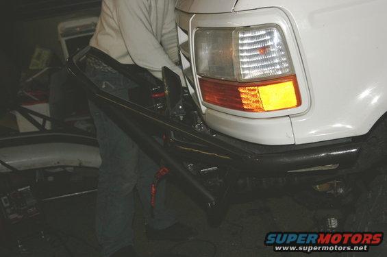 1995 Ford Bronco rear bumper and taillight assembly with a person working on it