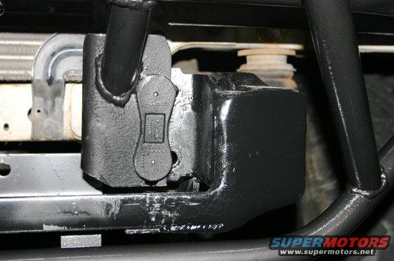 Close-up of a black tow hitch receiver attached to a vehicle frame, with part of the radiator visible