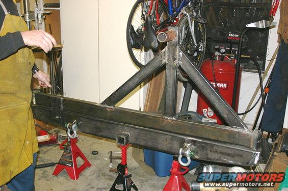 welding a custom rear bumper and tire carrier assembly on jack stands