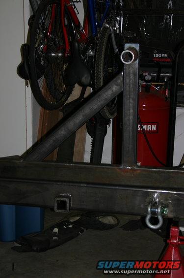 Custom metal fabrication project in progress, with bicycles and a red air compressor in the background