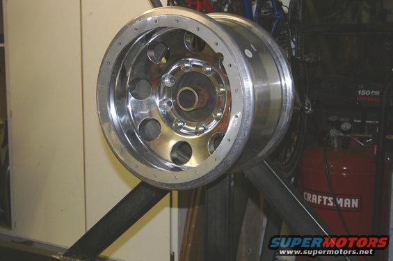Chrome wheel with 8 lug nuts on display stand