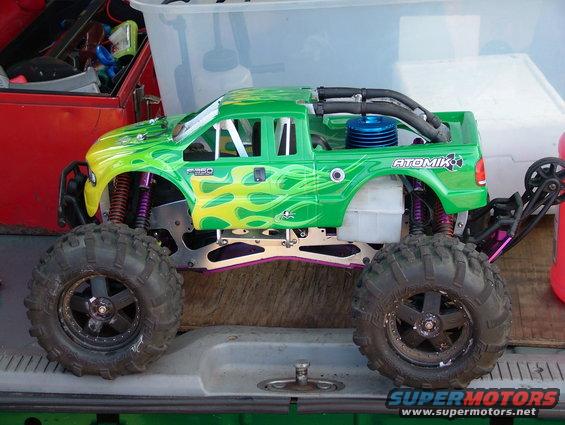 Green RC monster truck with flames, F-350 badging, and ATOMIK logo