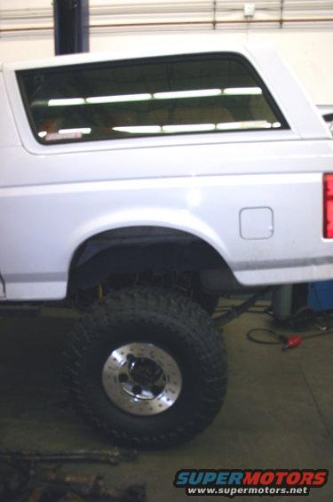 Side view of a white 1995 Ford Bronco with large off-road tires