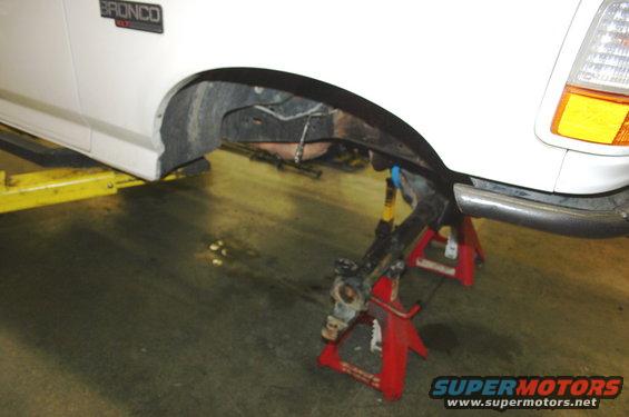 1995 Ford Bronco front suspension on jack stands, showing coilover and brake components