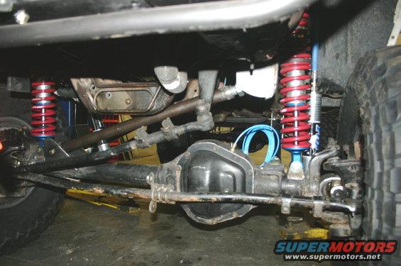 Undercarriage view of red coilover shocks and differential