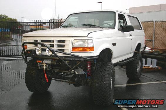White 1995 Ford Bronco with custom front bumper, winch, and large off-road tires