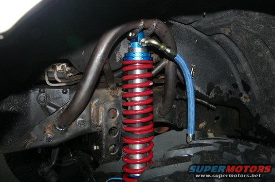 Front suspension with red coilover shock absorber and blue braided line