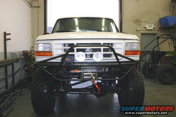 White Ford truck front view with custom bumper and winch