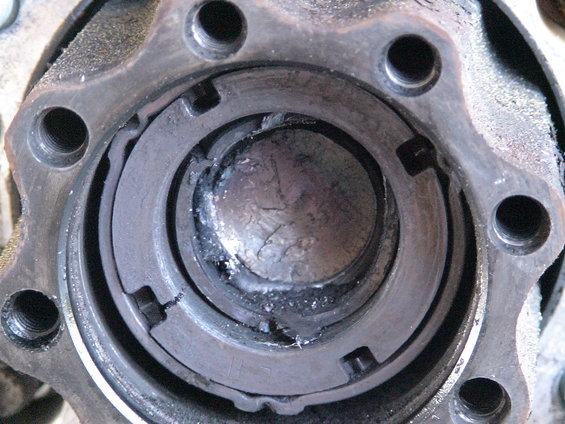 Close-up of a damaged wheel hub assembly with broken metal pieces inside