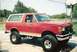 1990 Ford Bronco - This lifted 1990 Ford Bronco features a two-tone red and white paint scheme and aggressive off-road tires.