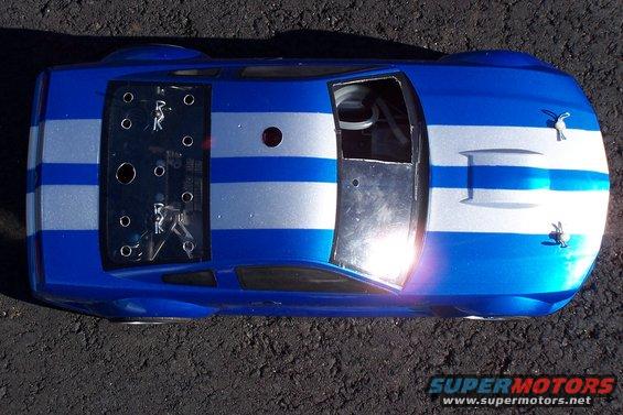Blue and silver striped race car from above, with visible interior and racing decals