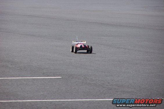 Red remote control car on asphalt with white lines