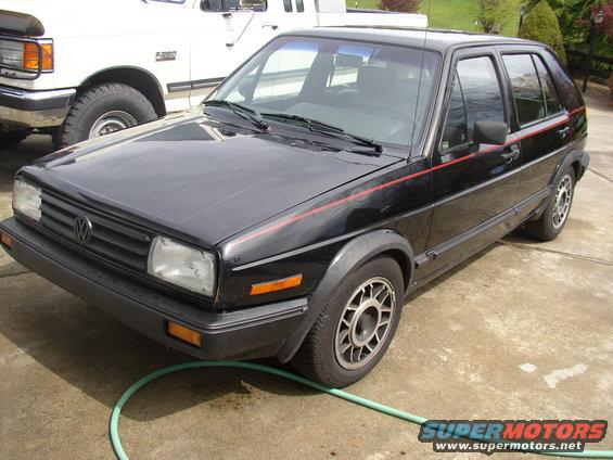 Black 1987 Volkswagen Golf with red pinstripes parked on concrete