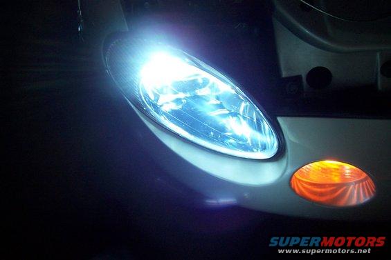 Close-up of a bright headlight and amber turn signal on a vehicle