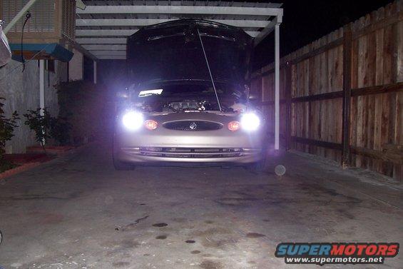 Front view of a 1998 Mercury Sable with hood open and headlights on