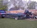 1982 Hydra-Sports Hydra-Sports prior to 2002 - A boat with a large Mercury outboard motor is parked on a trailer, hitched to a truck, with a lawnmower nearby.