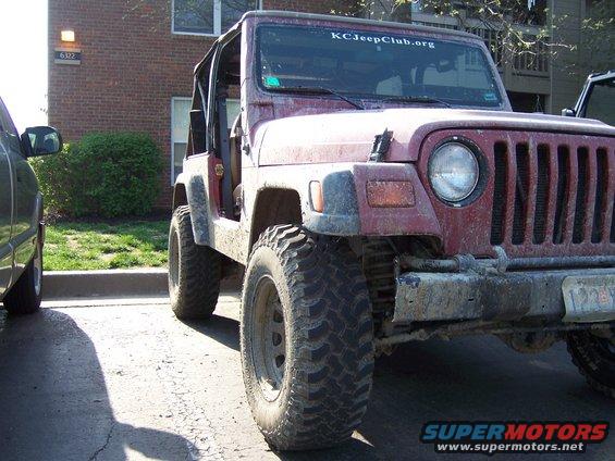 Maroon Jeep Wrangler parked next to another vehicle. It has a "KCJeepClub.org" sticker on the windshield
