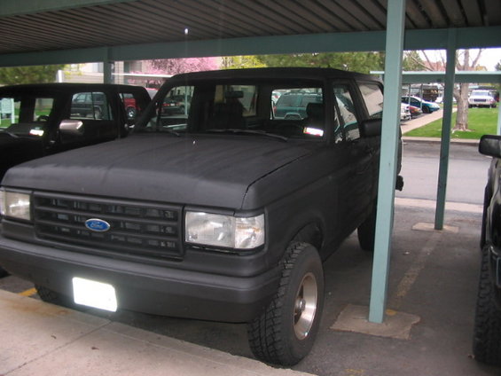 1991 Ford Bronco parked under a carport, front 3/4 view