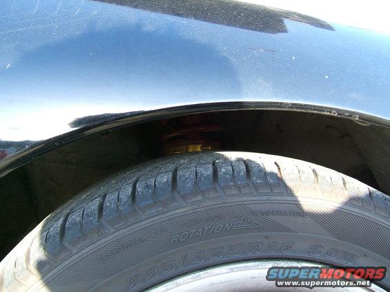 Close-up of a car's wheel well showing the tire and suspension. Tire size is 225/45ZR16