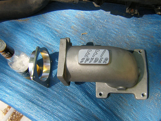 EFI SPYDER intake manifold and adapter plate on blue tarp, next to a beer bottle