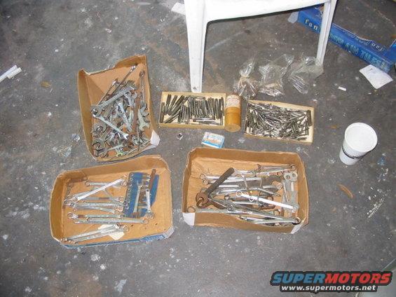 Boxes of wrenches and other tools on a concrete floor