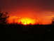 1995 Ford Probe - Vibrant sunset paints the sky with fiery colors over a dark, silhouetted landscape.