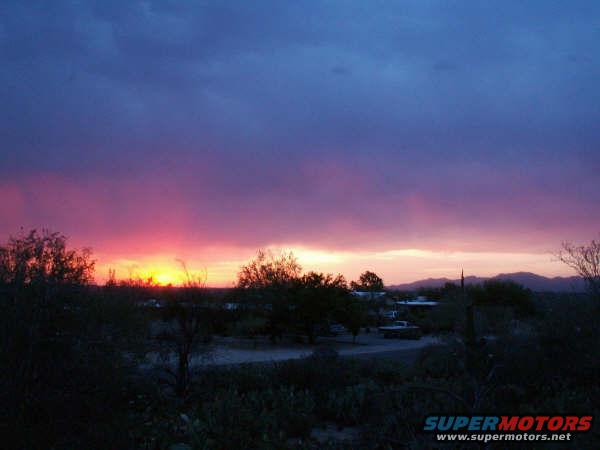 Sunset over desert with truck; SUPERMOTORS.NET text