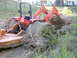 1995 Ford Bronco - An orange tractor is deeply stuck in mud, with its loader arm digging into the earth.