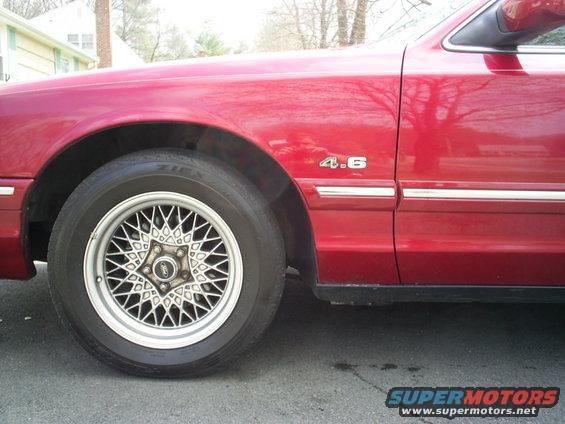 Red car fender with 4.6 badge and wire wheel