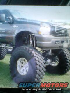 Gray Ford F-Series truck with large off-road tires and lifted suspension