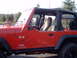 1991 Ford Bronco - Side view of a red Jeep Wrangler TJ, with "TJ" and "Jeep Wrangler" badging clearly visible.