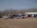 1991 Ford Bronco - Multiple vehicles, trailers, and a building are visible in this outdoor scene.
