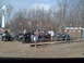 1991 Ford Bronco - Several ATVs are parked in a dirt lot, with people milling about near portable toilets and trees.