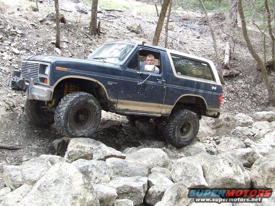 Dark blue 1986 Ford Bronco navigating a rocky trail