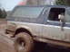 1991 Ford Bronco - Muddy Ford Bronco navigates off-road terrain.