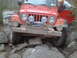 1991 Ford Bronco - A red Jeep Wrangler is shown off-roading on a challenging rocky path.