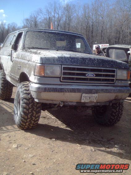Mud-covered Ford Bronco with big tires. License plate 292N024 visible