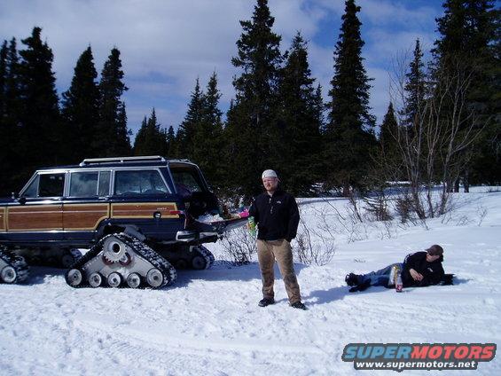 Wood-paneled SUV with tracks in the snow, side view