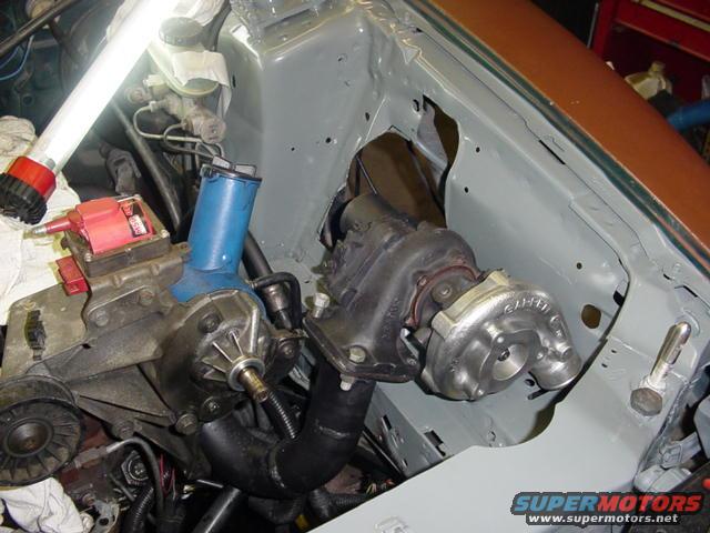 engine bay with a turbocharger installed, showing exhaust manifold and intake piping