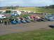 2001 Ford Fiesta - A scene of an outdoor event with multiple vehicles parked near food stalls and a grassy field.