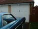 1970 Ford Ranchero - A blue 1970 Ford Ranchero is parked in front of a white garage door with a red wooden fence to the right.