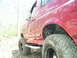 1994 Ford Bronco - This red SUV, likely from the early to mid-1990s, is equipped for off-road use with large tires.