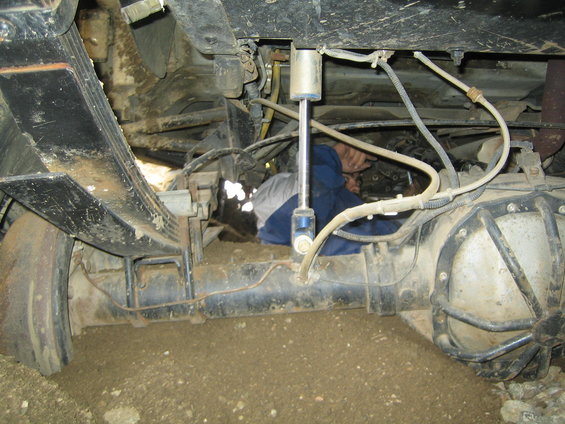 Person working on rear axle and suspension of a vehicle