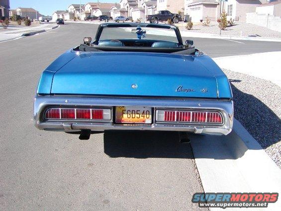 Rear view of blue convertible with 'Cougar XR7' badge and license plate FGD540
