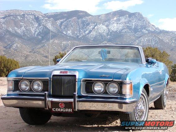 Blue 1973 Mercury Cougar convertible front view with mountains in background