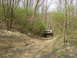 1989 GMC Jimmy - A 1989 GMC Jimmy navigates a wooded trail, kicking up dust on the dirt path.