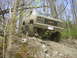 1989 GMC Jimmy - Modified 1989 GMC Jimmy tackling a challenging off-road course in a wooded area.