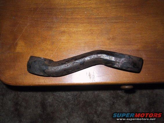 Curved metal part on wooden surface