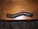 1990 Ford Bronco - A single, curved metal part is shown resting on a wooden surface.